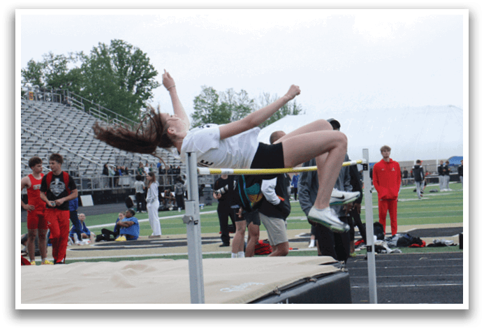 A woman is jumping over a bar in a track meet. Contenido generado con IA