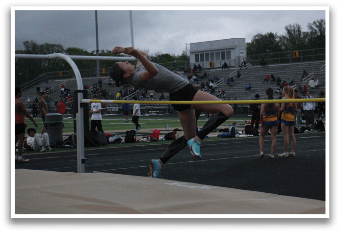 A female athlete jumps over a bar during a track meet. Contenido generado con IA