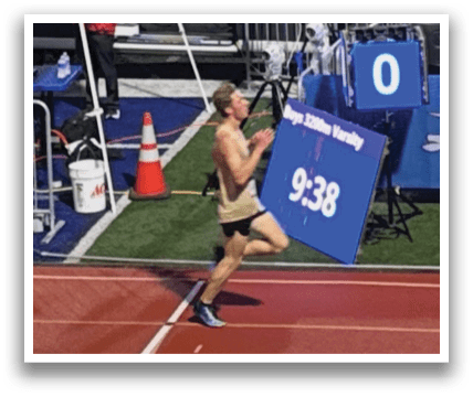 A man is running on a track with a sign in front of him. Contenido generado con IA