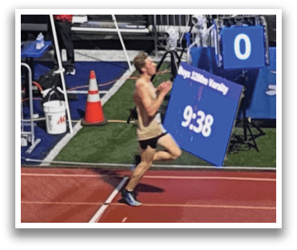 A man is running on a track with a sign in front of him. Contenido generado con IA