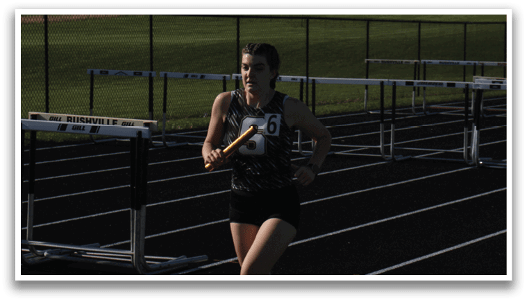 A runner is running on a track with a pole in his hand. Contenido generado con IA