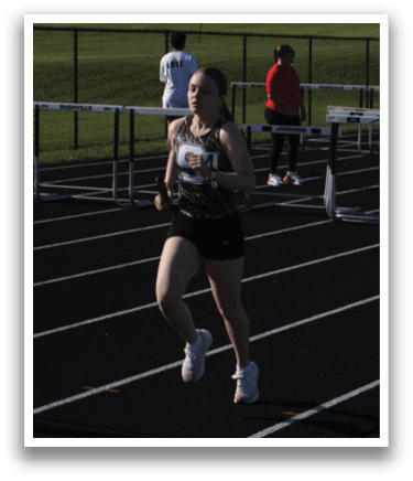 A woman is running on a track, wearing a black and white outfit. Contenido generado con IA