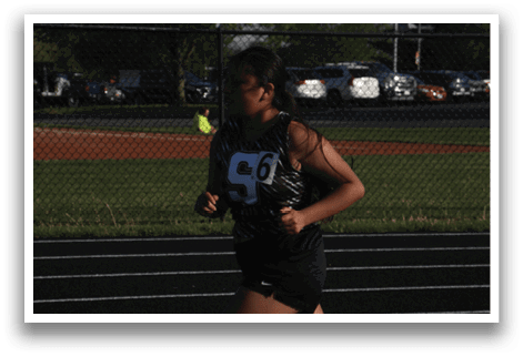 A woman is running on a track, wearing a black and white outfit. Contenido generado con IA