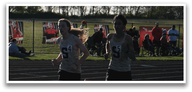 Two runners are racing on a track, one with the number 5 on their shirt. Contenido generado con IA