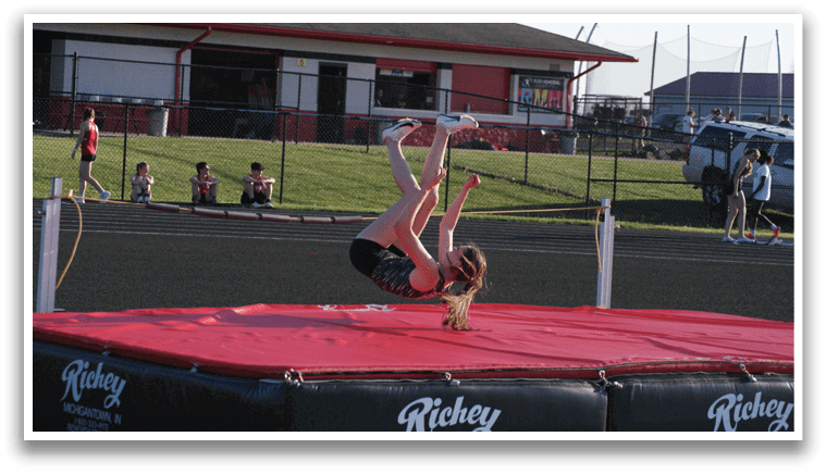 A woman is performing a handstand on a red mat. Contenido generado con IA