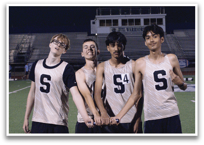 Four young men wearing sports uniforms pose for a photo on a field. Contenido generado con IA
