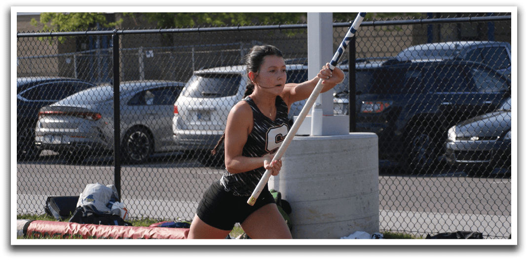 A woman is running on a track while holding a pole. Contenido generado con IA