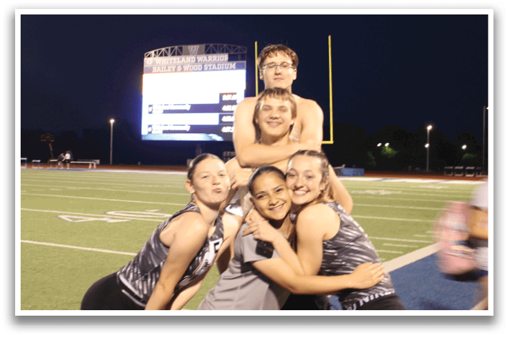 A group of cheerleaders pose on the field. Contenido generado con IA