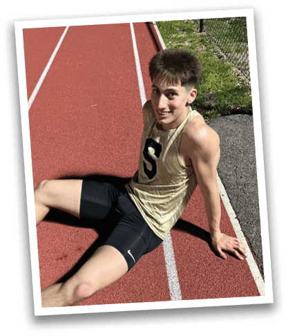 A man is lying on the ground on a track, wearing a track suit. Contenido generado con IA