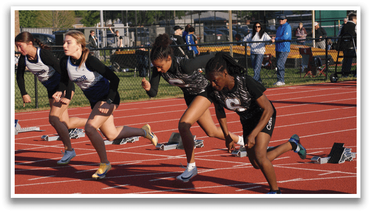 Two girls running on a track, one wearing a black shirt and the other wearing a white shirt. Contenido generado con IA