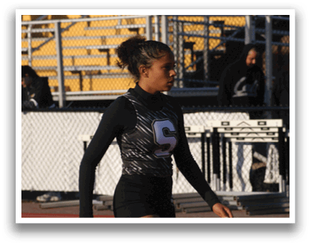 A female athlete wearing a black and white uniform is walking on a track. Contenido generado con IA