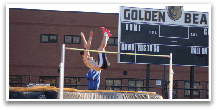 A man is jumping over a bar in a track and field event. Contenido generado con IA