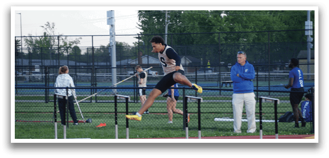 A man is jumping over a hurdle in a track meet. Contenido generado con IA