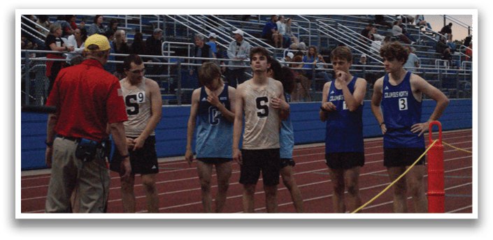 A group of young men are standing on a track, wearing uniforms and holding their hands on their hips. Contenido generado con IA