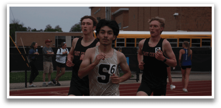 Three men are running on a track, with one of them wearing a number 56 shirt. Contenido generado con IA