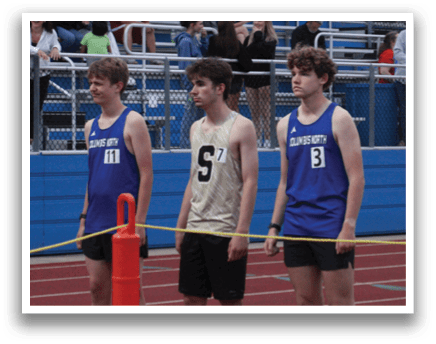 Three young men are standing on a track, wearing athletic clothing and waiting for the starting gun. Contenido generado con IA