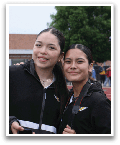 Two women wearing black jackets and holding cameras pose for a picture. Contenido generado con IA