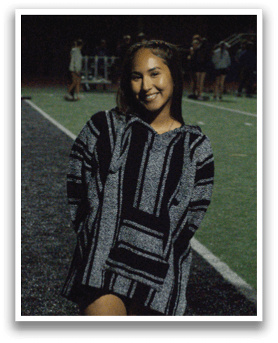 A woman wearing a black and white jacket is standing on a field. Contenido generado con IA