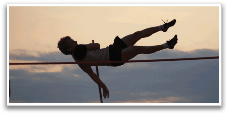 A man is seen jumping in the air, attempting to clear a pole. Contenido generado con IA