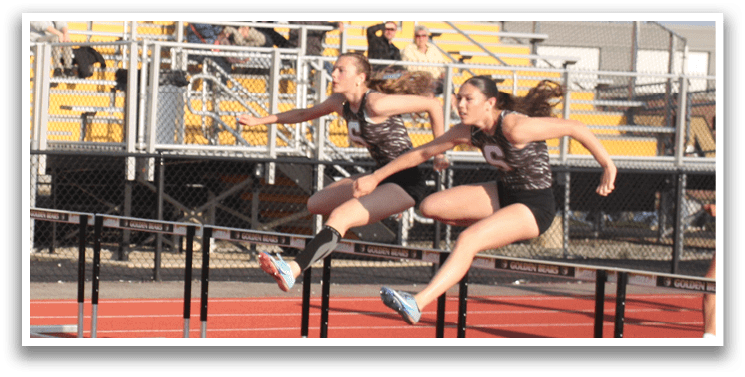 A female athlete is jumping over a barrier during a track and field event. Contenido generado con IA