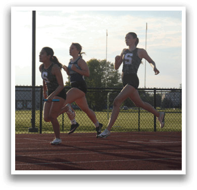 Three female runners are running on a track, with one in the lead and the other two following closely behind. Contenido generado con IA