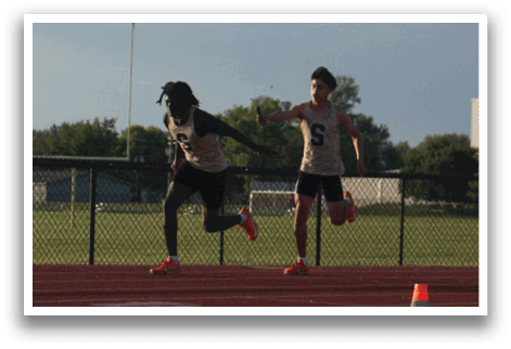 A group of people are running on a track, with one person wearing a black shirt and orange shoes. Contenido generado con IA