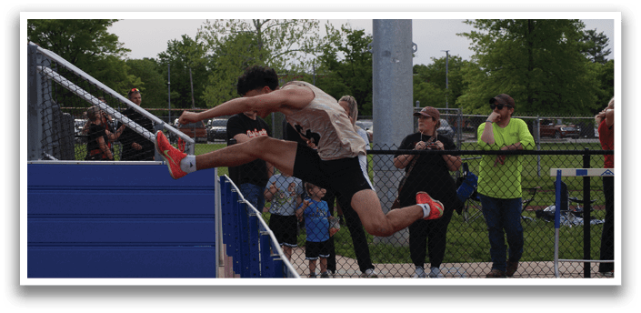 A man is jumping over a barrier on a track. Contenido generado con IA