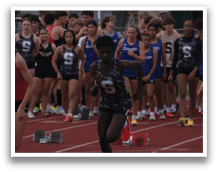 A group of people running on a track, including a man in the lead. Contenido generado con IA