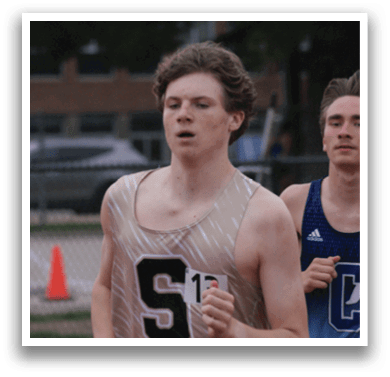 Two men are running on a track, one wearing a black and white shirt and the other wearing a blue shirt. Contenido generado con IA
