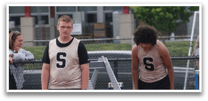 A group of people are standing on a track, with some of them wearing number tags. Contenido generado con IA