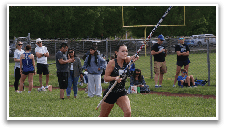 A woman is holding a pole and jumping in a grassy field. Contenido generado con IA