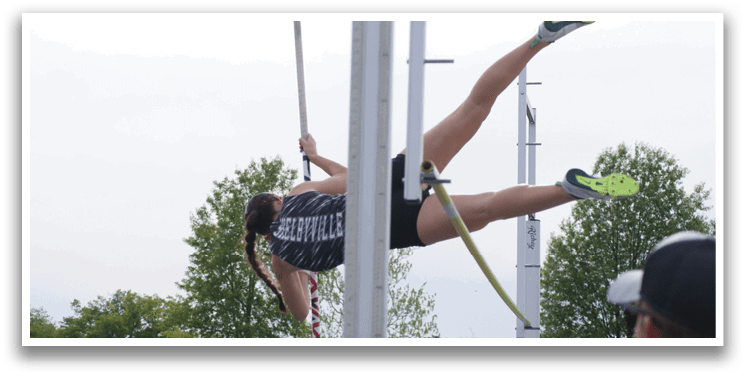 A woman is seen jumping in the air, holding a pole in her hand. Contenido generado con IA