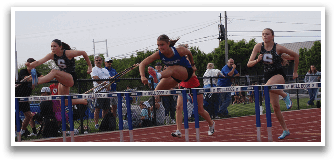Three female athletes are running on a track, jumping over hurdles. Contenido generado con IA