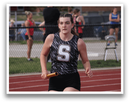 A woman is running on a track while holding a baton. Contenido generado con IA