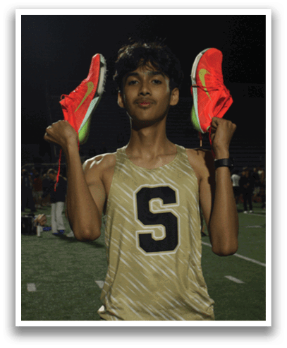 A man wearing a track suit is holding two shoes in his hands. Contenido generado con IA