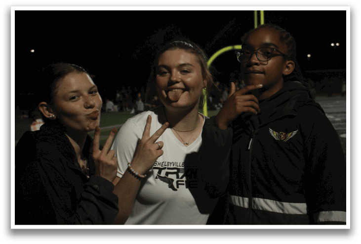 Three people pose for a picture, two of them making peace signs. Contenido generado con IA