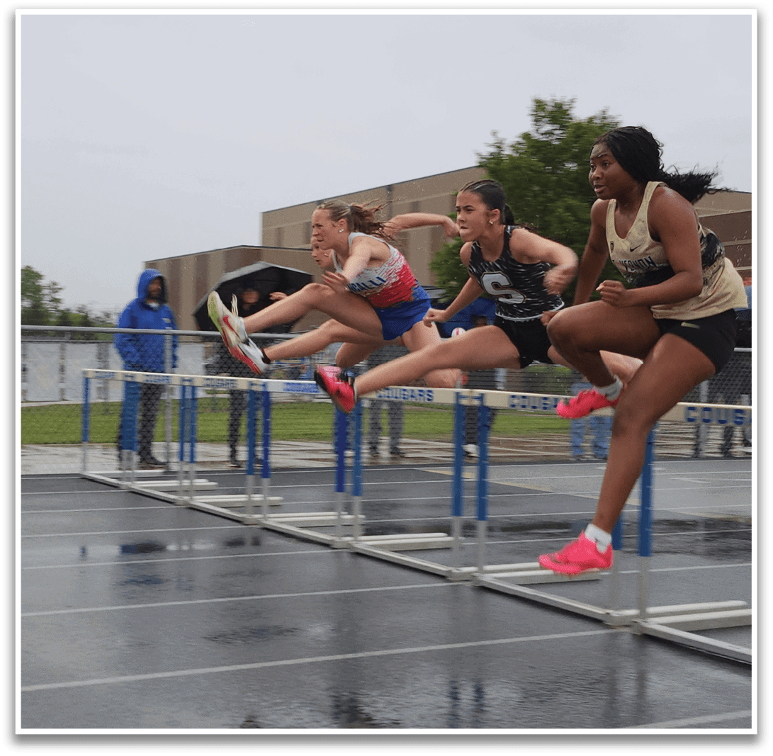 Three women are running on a track, jumping over a barrier. Contenido generado con IA