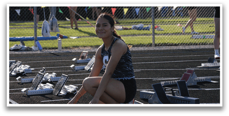 A woman is squatting on a track with her legs spread. Contenido generado con IA