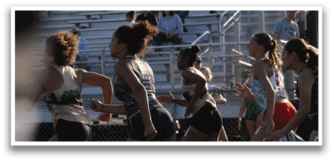 A group of girls running on a track, some wearing shorts. Contenido generado con IA