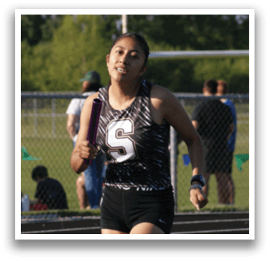 A woman is running on a track, wearing a black and white outfit. Contenido generado con IA