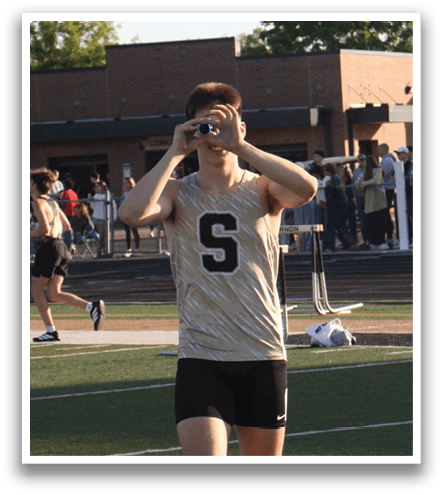 A man wearing a gold and black uniform stands on a field. Contenido generado con IA