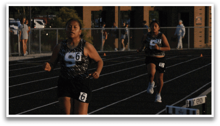 Three female runners are running on a track. Contenido generado con IA