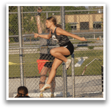 A group of girls are playing a game of frisbee on a field. One girl is jumping in the air to catch the frisbee. Contenido generado con IA