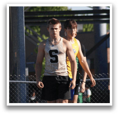 A group of young men are running on a track, with one of them wearing a white shirt. Contenido generado con IA