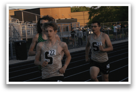 Two men are running on a track, one wearing a number 21 shirt. Contenido generado con IA