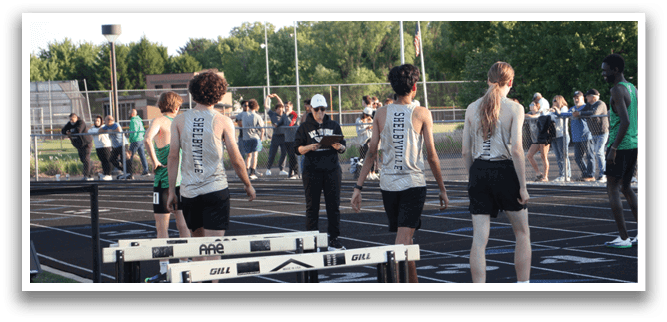 A group of people are standing on a track, some of them wearing uniforms. Contenido generado con IA