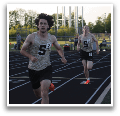 Two men are running on a track, one wearing a number 6 shirt. Contenido generado con IA