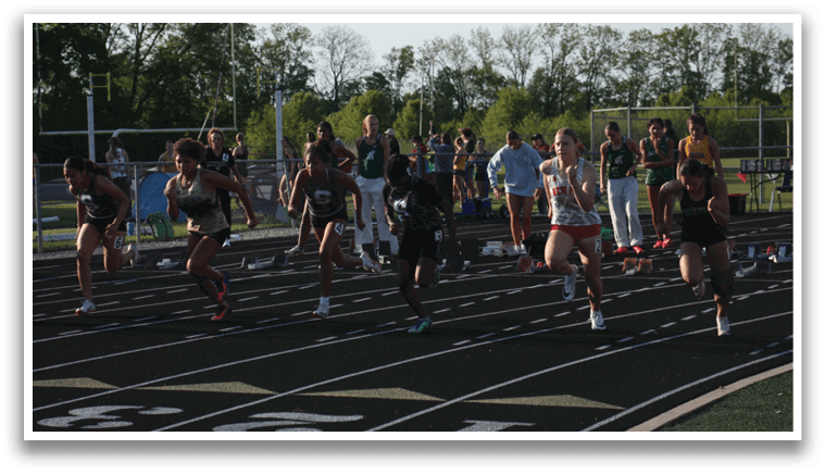 A group of people are running on a track, with some of them wearing red shorts. Contenido generado con IA