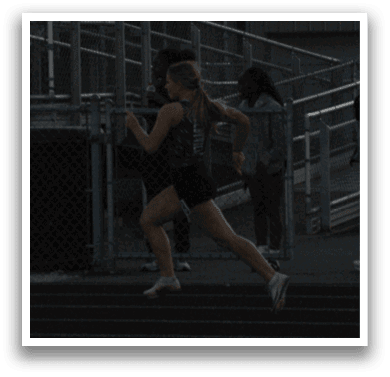 A group of people are standing on a track, watching a woman run. Contenido generado con IA