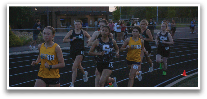 A group of girls are running on a track, wearing numbers on their shirts. Contenido generado con IA